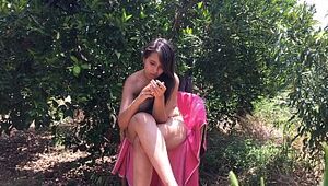 Chica joven de 18 años sentada desnuda entre árboles